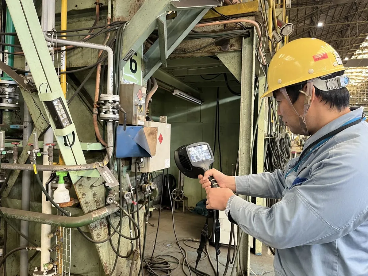 工場内でエア漏れ可視化カメラを使って配管まわりを点検する様子